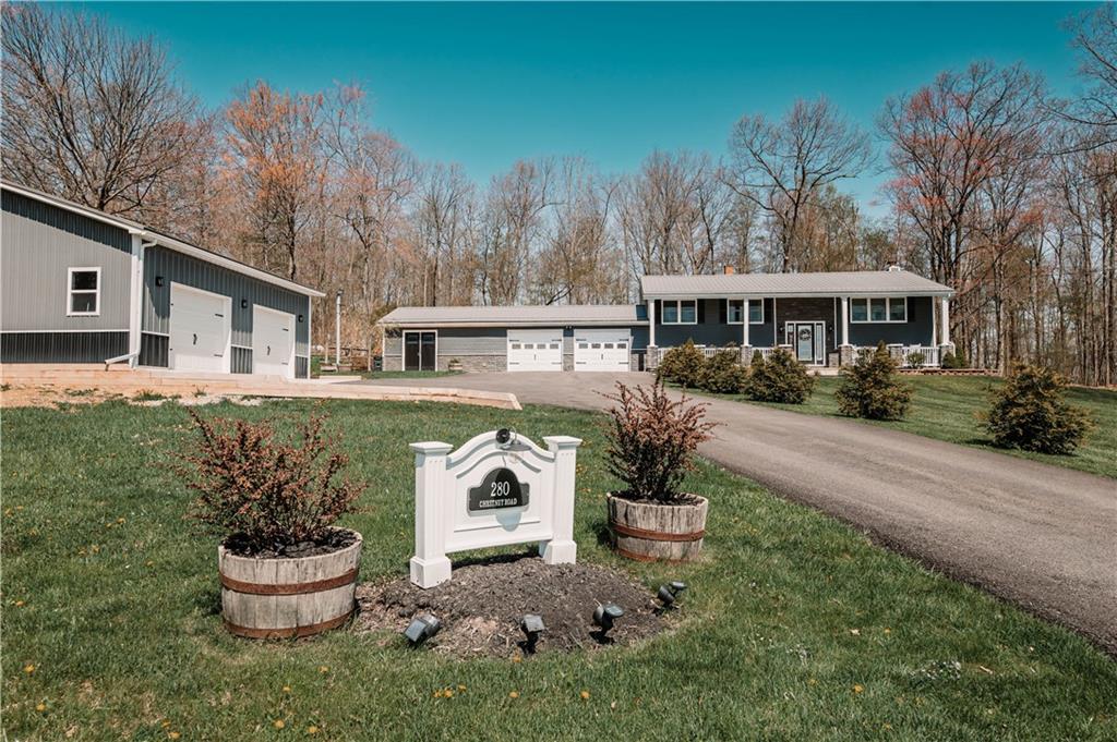a front view of a house with a yard and lake view