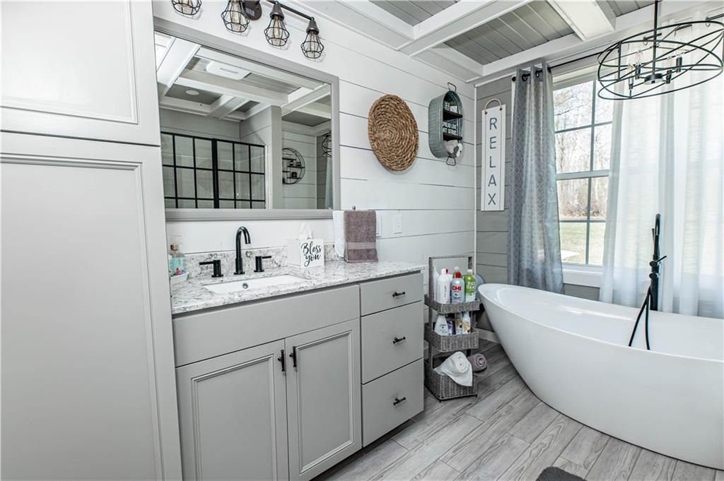 280 Chestnut Road Penn Run, PA 15765 - Photo 17 of 25 a bathroom with a bathtub a sink a mirror and a window