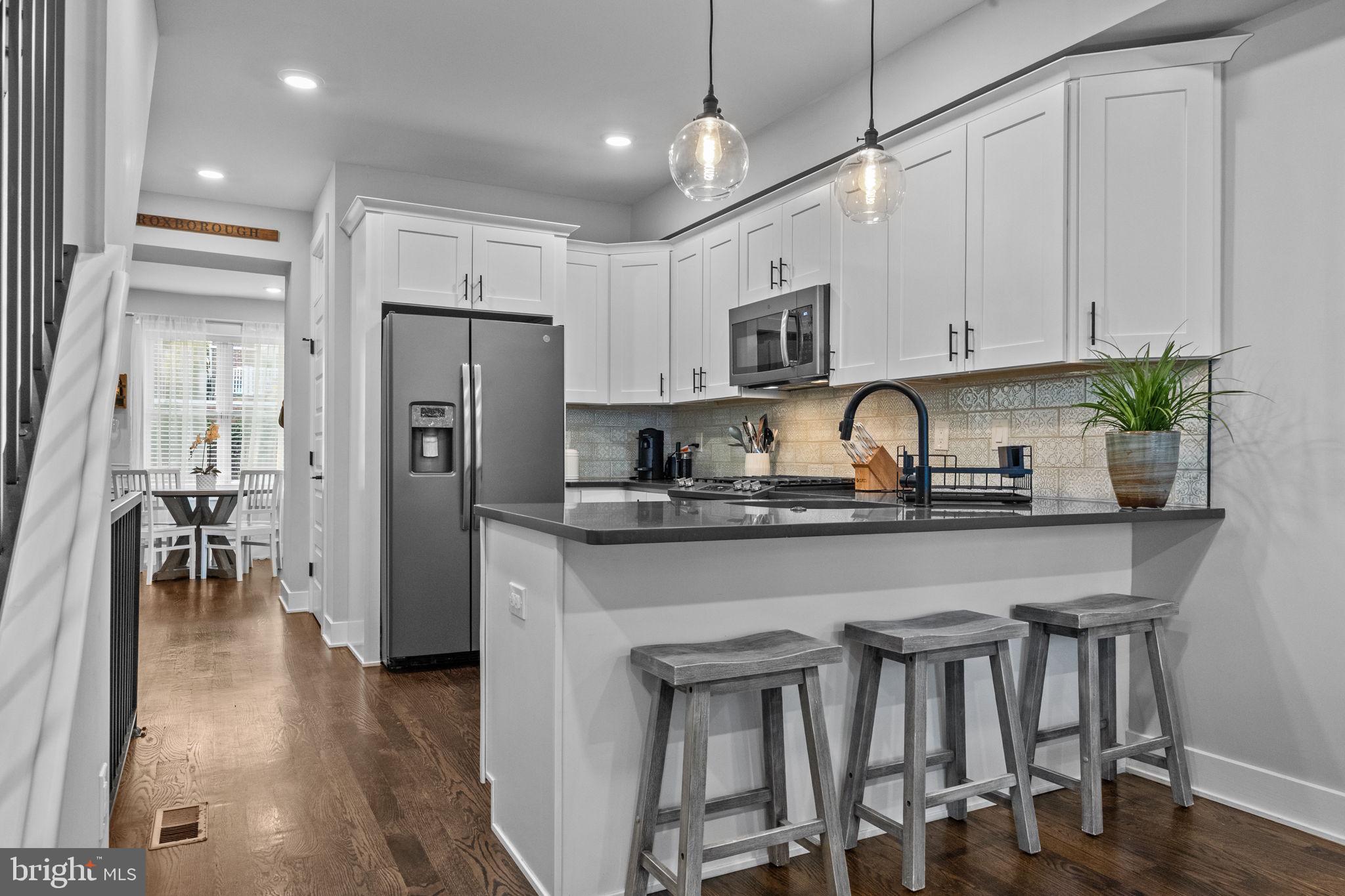 450 Ripka Street Philadelphia, PA 19128 - Photo 10 of 47 a kitchen with stainless steel appliances granite countertop a refrigerator a sink a stove a dining table and chairs with wooden floor