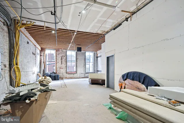 a bedroom with furniture and a large window