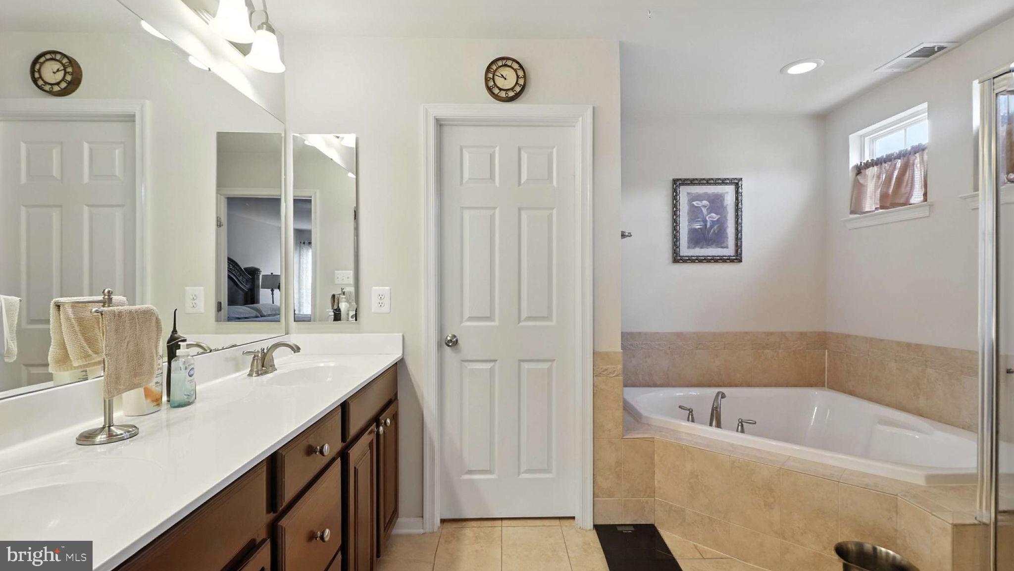13511 Bermingham Manor Drive Laurel, MD 20708 - Photo 10 of 51 a bathroom with a tub a sink and a mirror