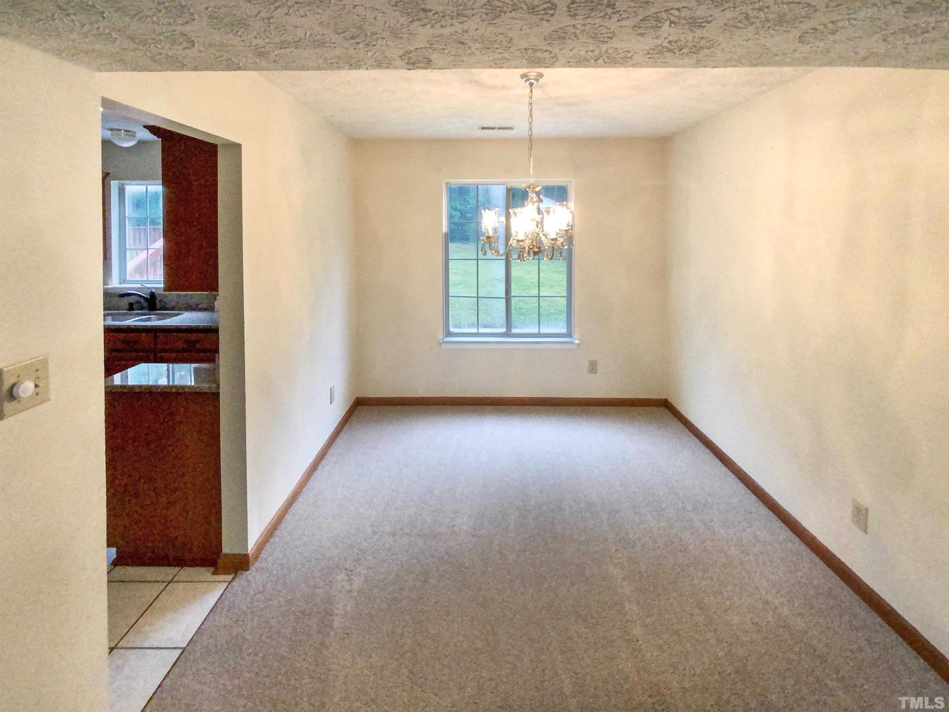 6509 Hammersmith Drive Raleigh, NC 27613 - Photo 9 of 20 an empty room with windows and chandelier