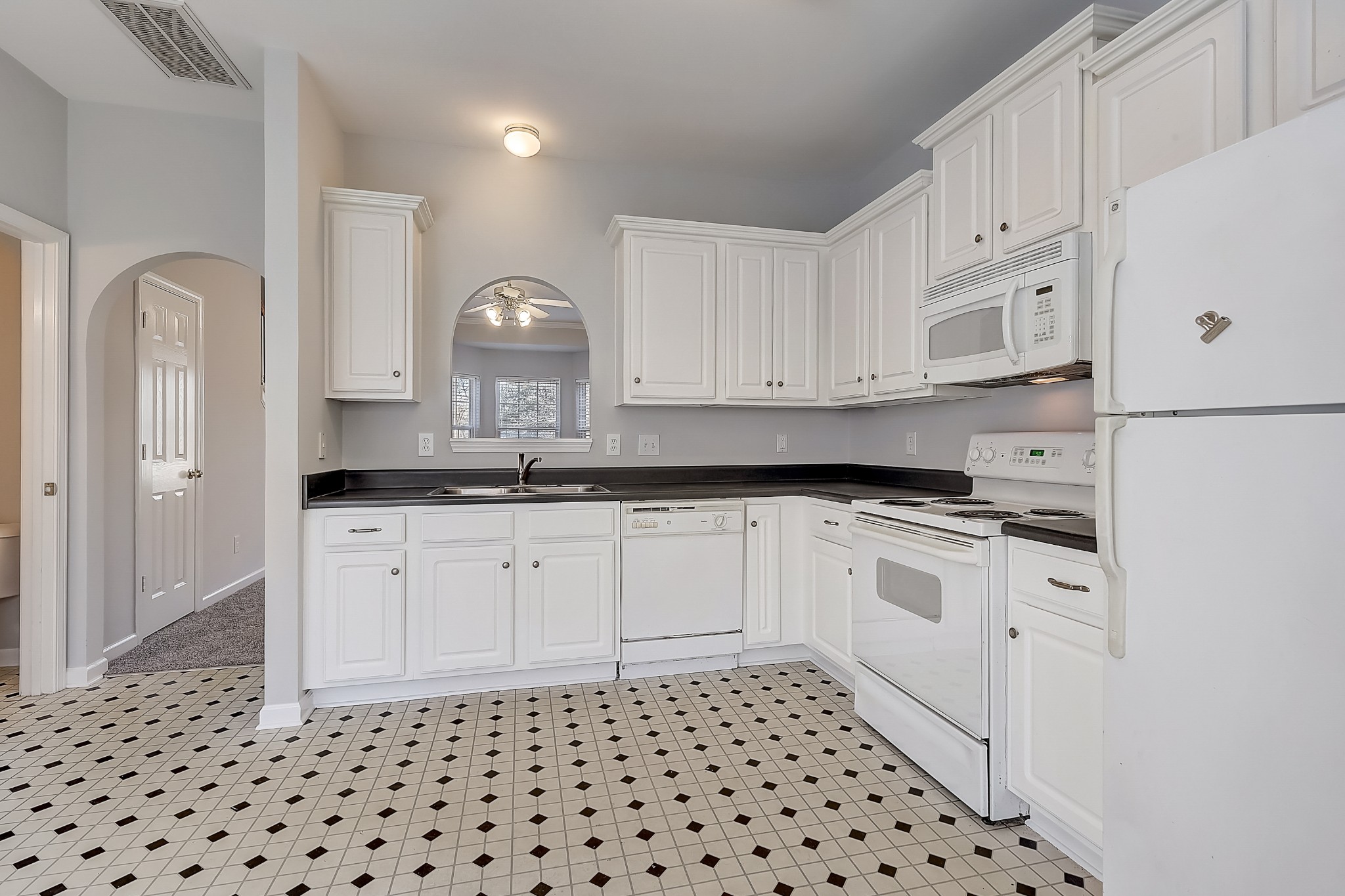 1101 Downs Boulevard, Unit 80 Franklin, TN 37064 - Photo 9 of 19 a kitchen with granite countertop white cabinets and black appliances