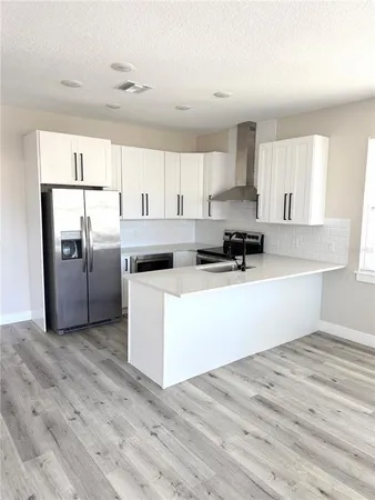 a kitchen with stainless steel appliances a refrigerator sink and cabinets