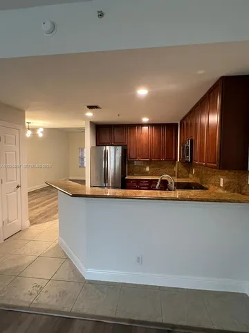 a large kitchen with stainless steel appliances a large counter top