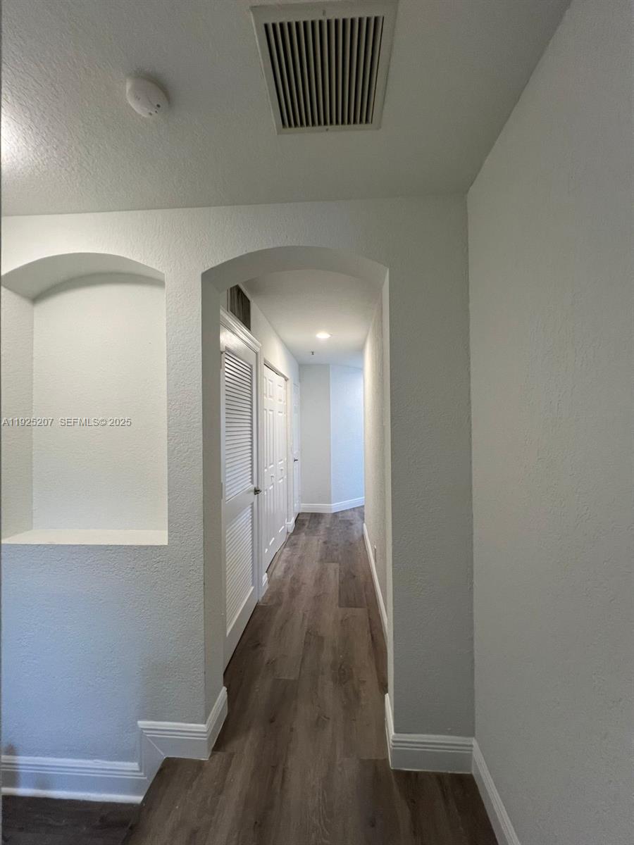 22 Southwest 6th Court, Unit 22 Pompano Beach, FL 33060 - Photo 14 of 26 a view of a hallway with wooden floor and a bathroom