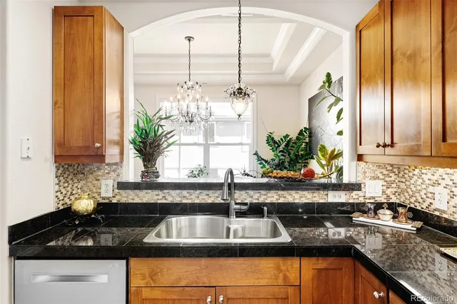 a kitchen with granite countertop a sink and a white wooden cabinets