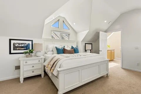 a bedroom with a bed and a painting on the wall