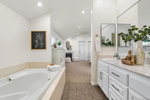 a spacious bathroom with a double vanity sink a mirror and a bathtub