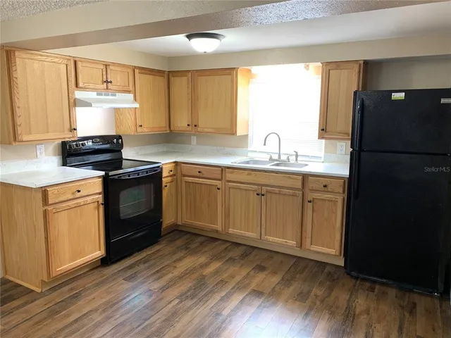 a kitchen with a sink stove and refrigerator