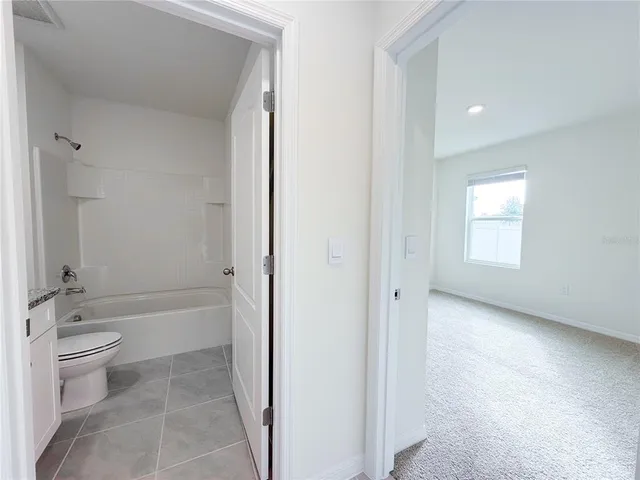 a bathroom with a granite countertop sink a toilet and a bathtub