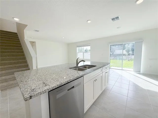 a kitchen with granite countertop a sink and a wooden floor