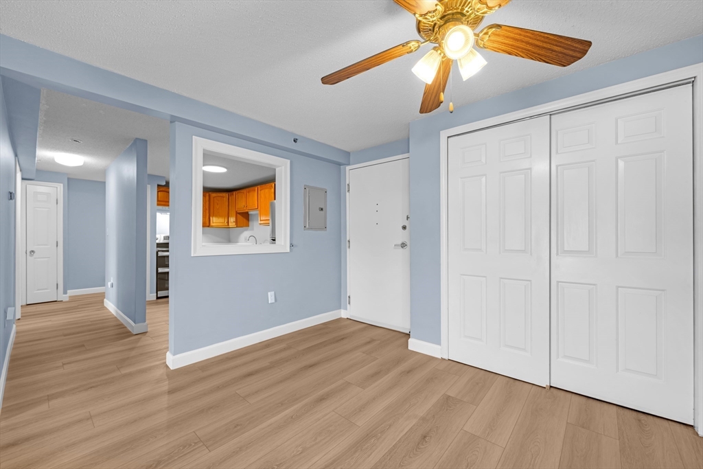 688 Boston Post Road East, Unit 228 Marlborough, MA 01752 - Photo 7 of 22 a view of an empty room with window and wooden floor