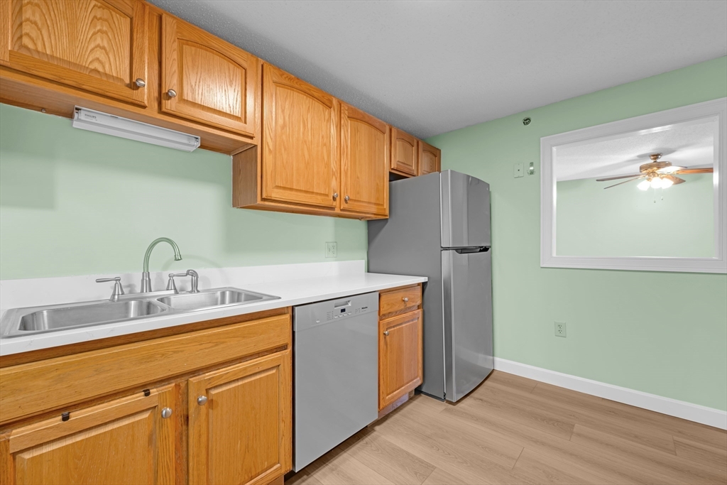 688 Boston Post Road East, Unit 228 Marlborough, MA 01752 - Photo 9 of 22 a kitchen with stainless steel appliances granite countertop a refrigerator sink and cabinets