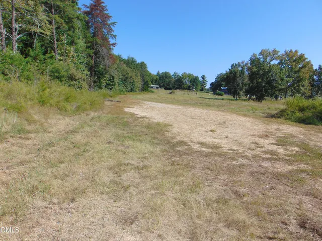 a view of a field with trees in background