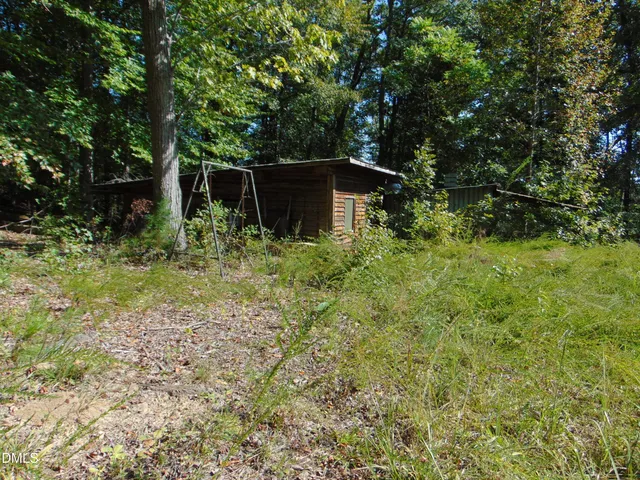 a backyard of a house with lots of plants and tree