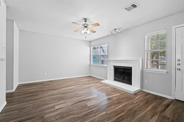 a view of empty room with wooden floor and fireplace