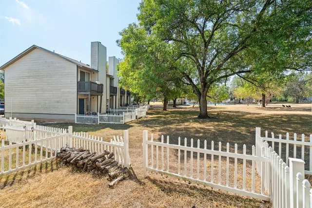 an empty room with windows and ceiling fan