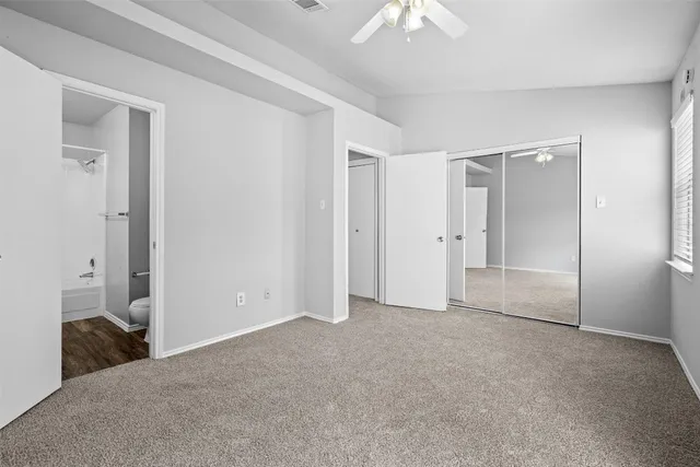 an empty room with windows and closet