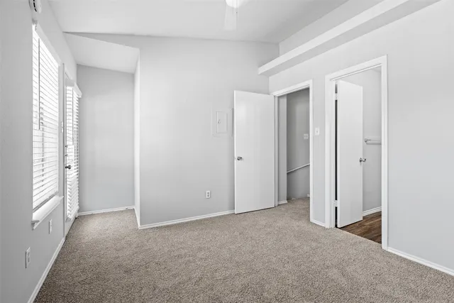 an empty room with windows and closet