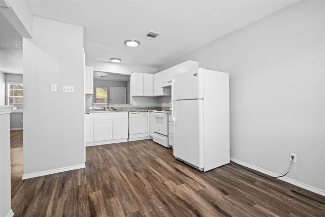 a kitchen with white cabinets and white appliances