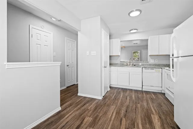 a kitchen with wooden floors and white appliances