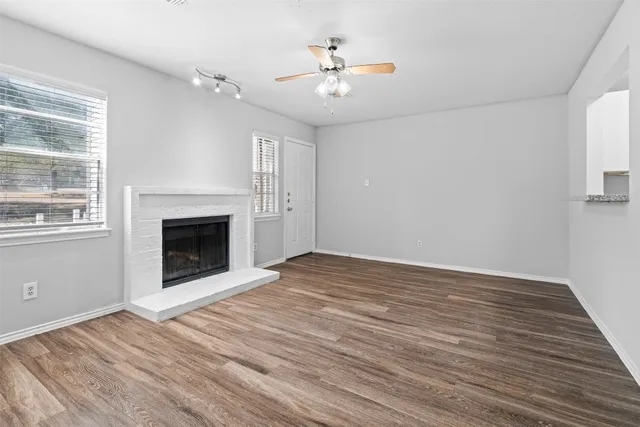 a view of empty room with fireplace and wooden floor