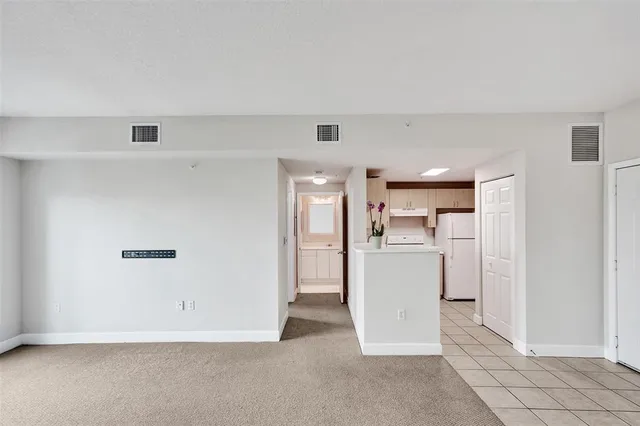 a view of a kitchen with a refrigerator a stove top oven and cabinets