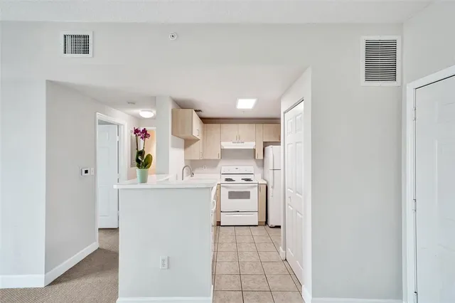 a kitchen with white cabinets and white appliances