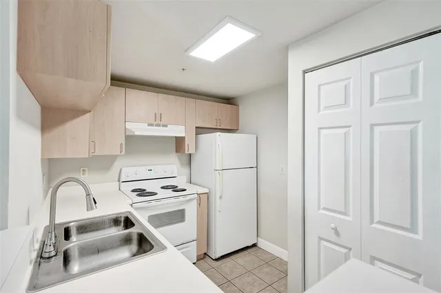 a kitchen with white cabinets and white appliances