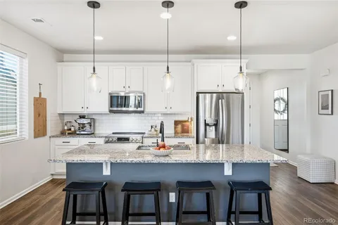 a kitchen with stainless steel appliances granite countertop a kitchen island a stove and a cabinets