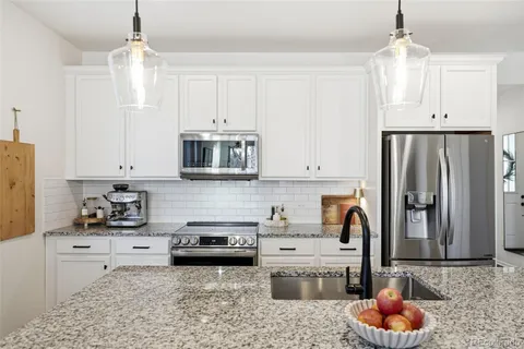 a kitchen with stainless steel appliances granite countertop a refrigerator sink and cabinets