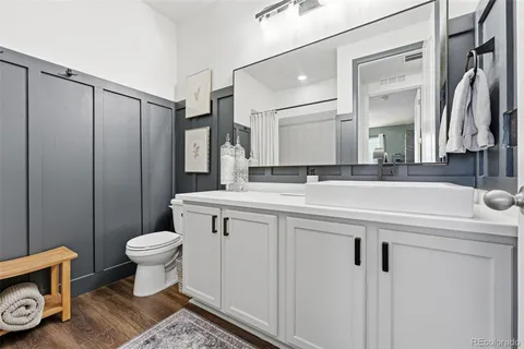 a bathroom with a sink a toilet a mirror and shower