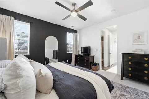 a bedroom with a bed a dresser and a chandelier