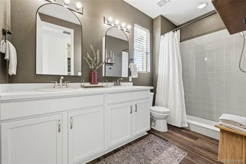 a bathroom with a double vanity sink mirror and toilet