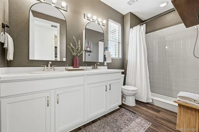 a bathroom with a double vanity sink mirror and toilet