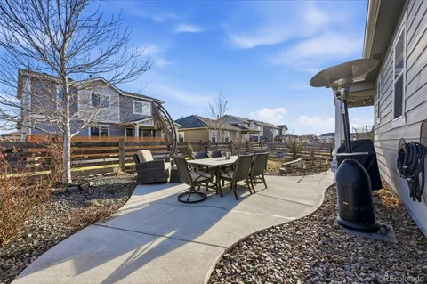 a view of a patio with table and chairs with wooden floor and fence
