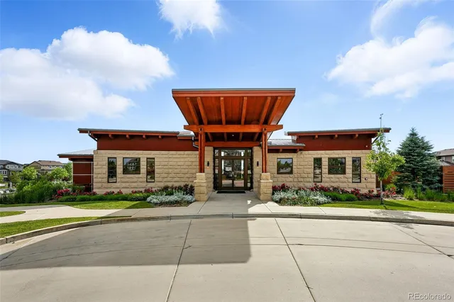 a front view of a house with a yard and potted plants