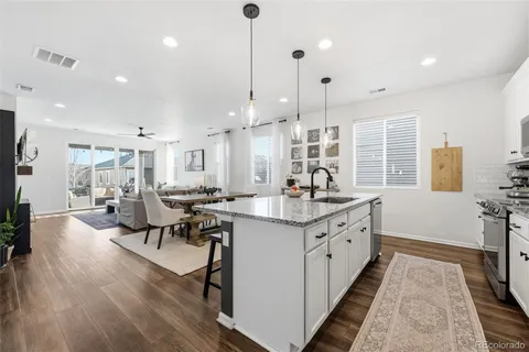 a kitchen with counter top space a sink appliances and living room view