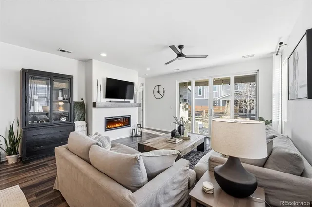 a living room with furniture a flat screen tv and a fireplace