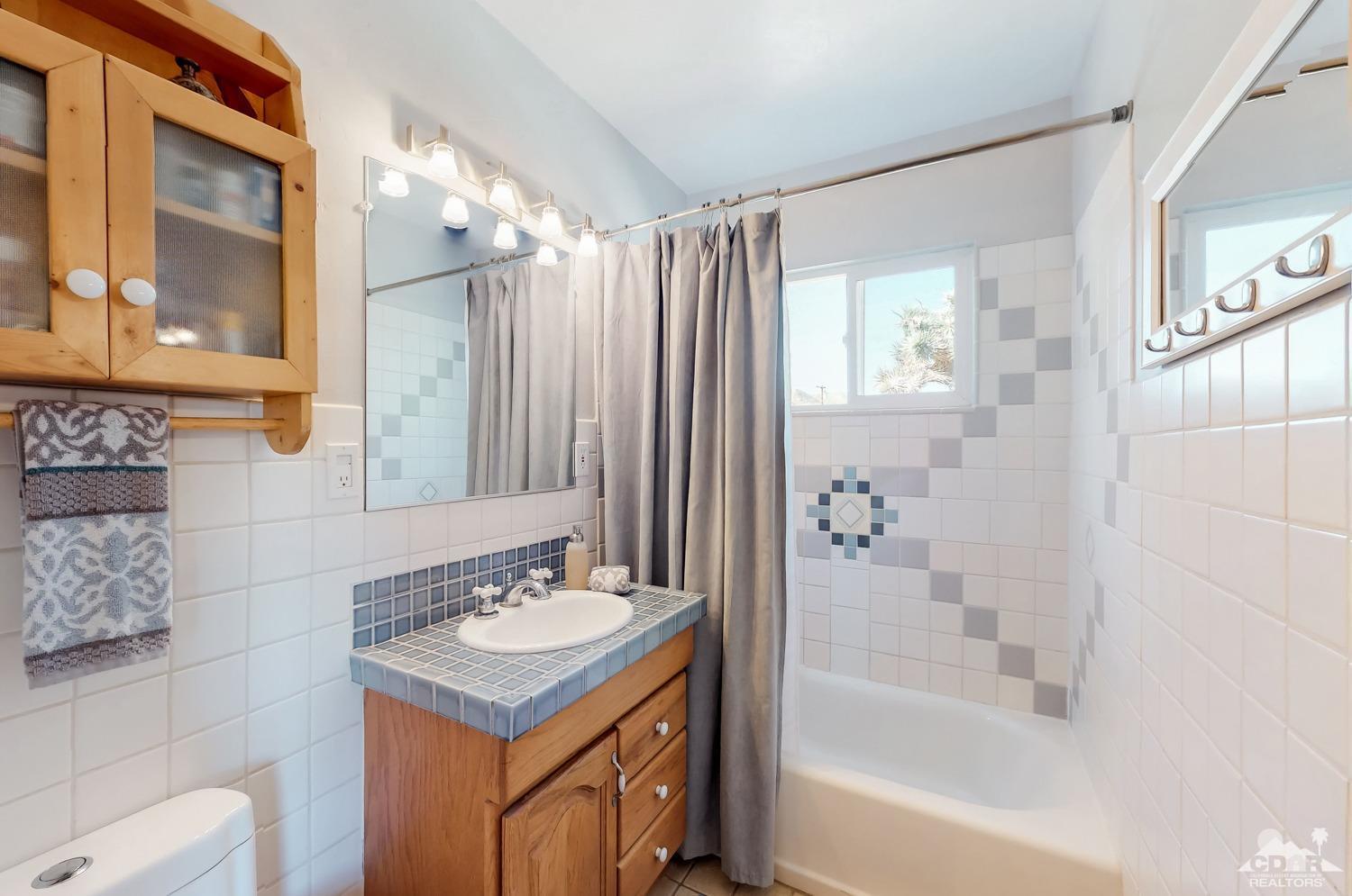 63443 Quail Springs Road Joshua Tree, CA 92252 - Photo 13 of 17 a bathroom with a bathtub sink vanity and mirror