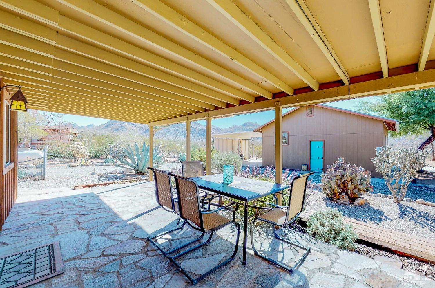 63443 Quail Springs Road Joshua Tree, CA 92252 - Photo 17 of 17 a view of a patio with a table and chairs under an umbrella