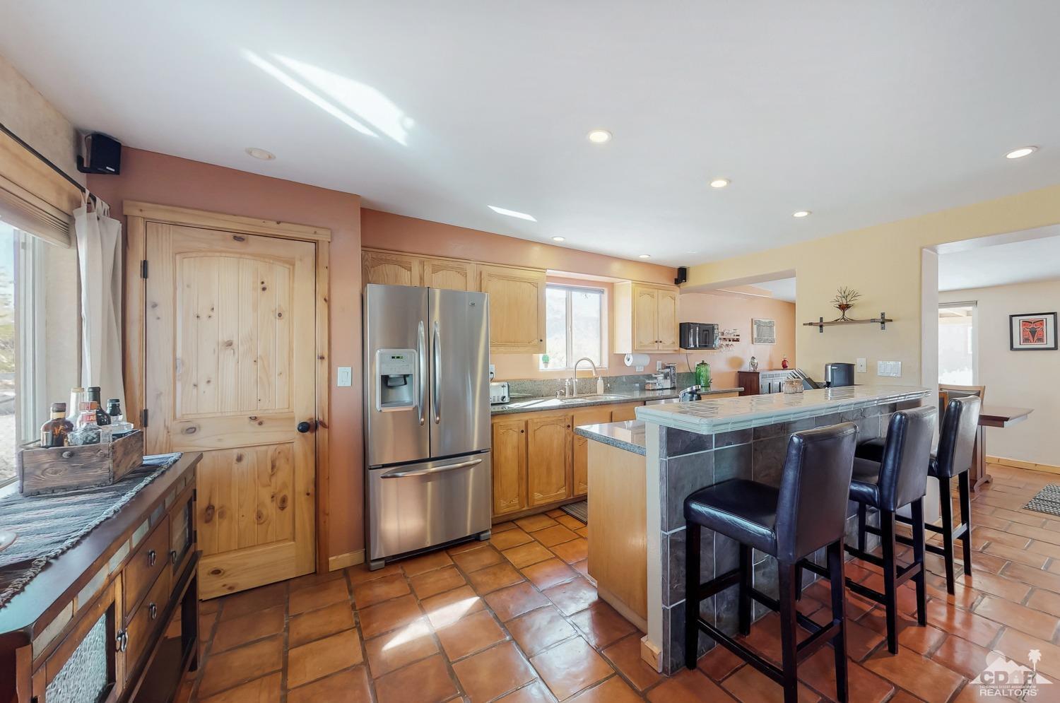 63443 Quail Springs Road Joshua Tree, CA 92252 - Photo 8 of 17 a kitchen with stainless steel appliances granite countertop a refrigerator and cabinets