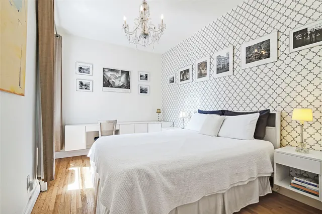 a bedroom with a large bed and a chandelier