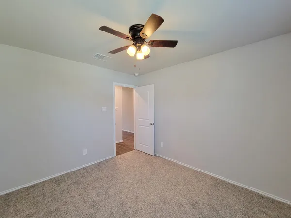 a large kitchen with stainless steel appliances a large counter top a sink and a refrigerator