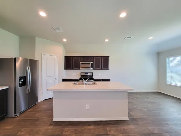 a view of kitchen with sink microwave and refrigerator