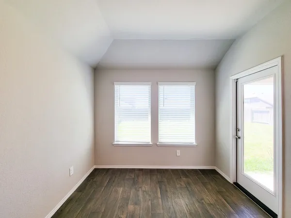 an empty room with a window and a ceiling fan