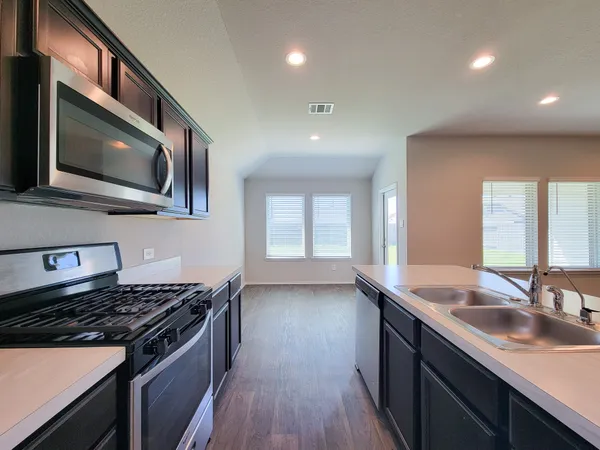 a kitchen with stainless steel appliances granite countertop a sink and a stove