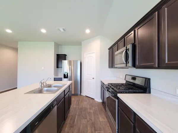 a kitchen with a sink a microwave and cabinets