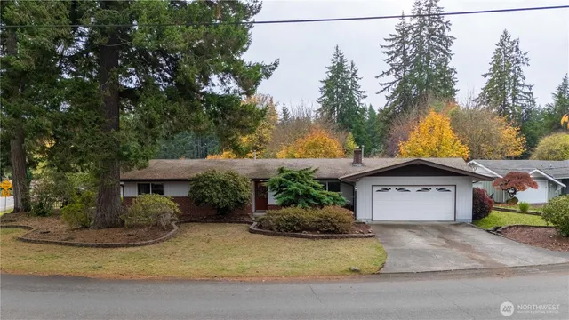 a front view of a house with a garden and trees